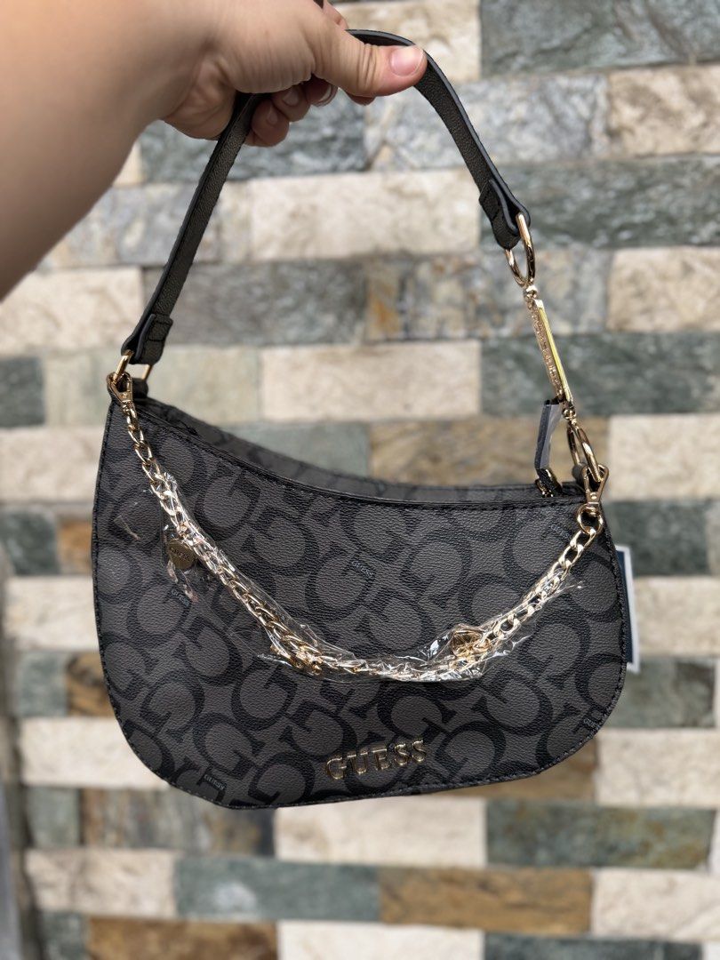 Guess Monogram Hobo Bag (Category: Luxury Bags & Wallets) located in Rizal. Submitted by bingbong21 (Listing ID 1457565825, Image 1). Description: - Authentic Grey Guess Hobo Bag - All-over monogram pattern for a stylish look - Elegant gold chain detail across the front - Adjustable strap for comfortable wear - Comes with original tag, brand new - Ideal for everyday use and adding flair to your outfits.