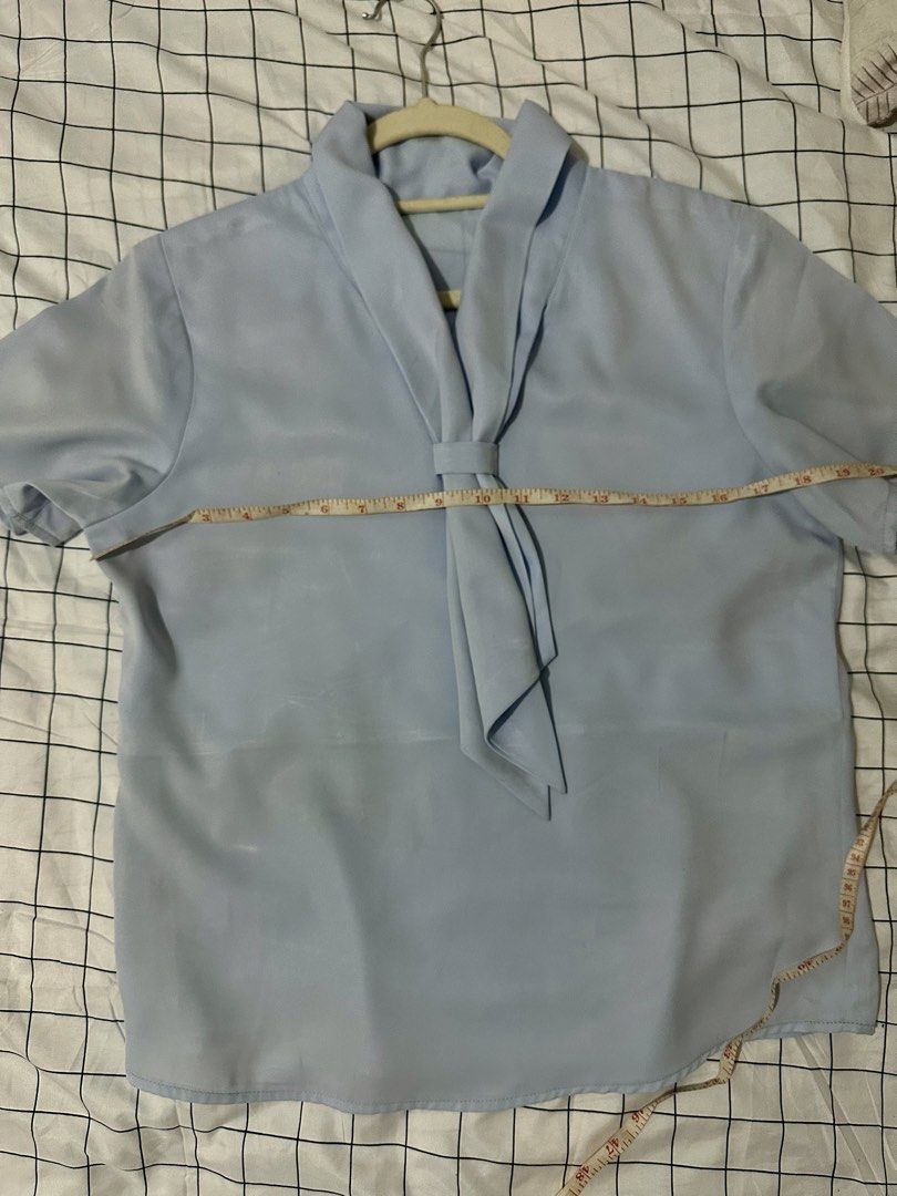Light Blue Short Sleeve Blouse with Tie Neck (Category: Blouses) located in Manila. Submitted by salmongirl88 (Listing ID 1457635348, Image 3). Description: - Light blue short-sleeved blouse - Elegant tie-neck detail - Fabric with a subtle sheen - Measurements: Approx. 23" length, 19" chest (pit to pit) - Versatile: Great for work or casual wear - Easy to style.
