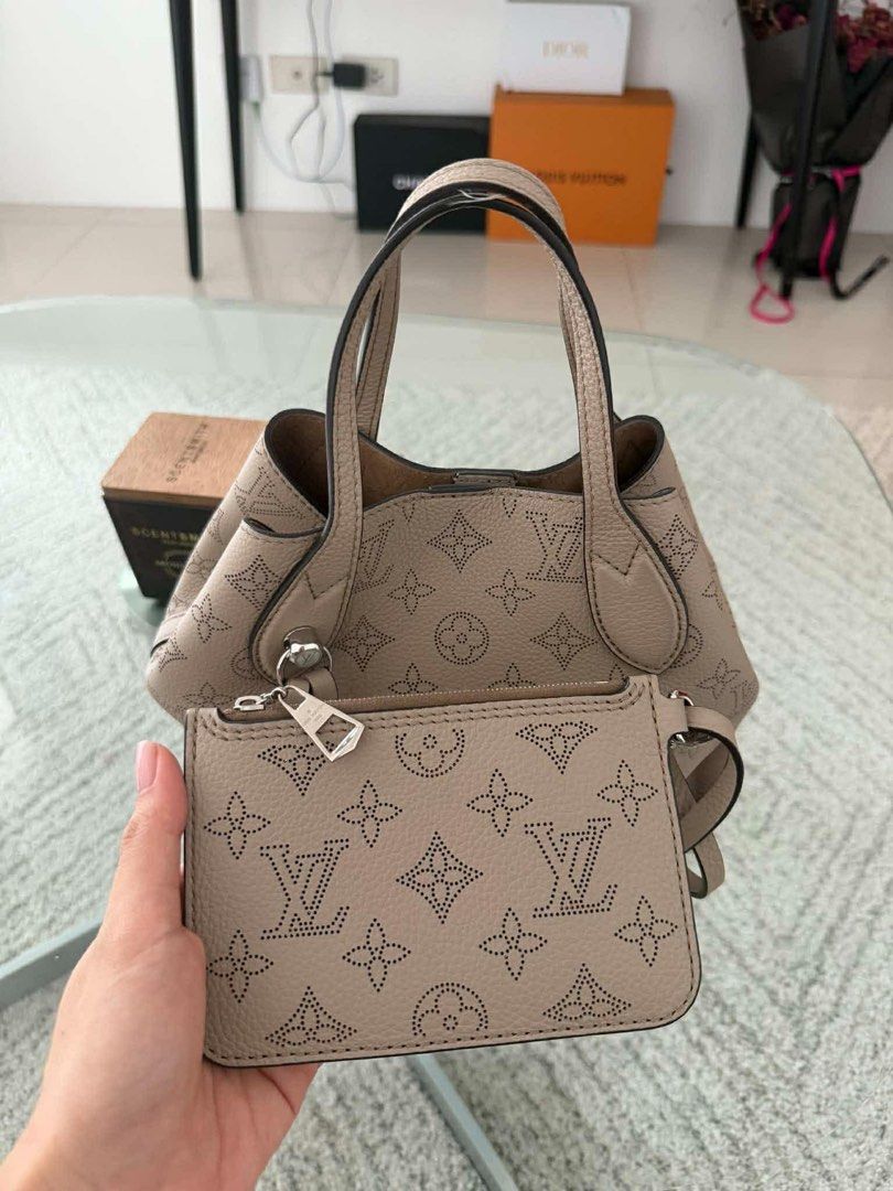 Louis Vuitton Mahina PM Blossom (Category: Luxury Bags & Wallets) located in Makati City. Submitted by joajoa5 (Listing ID 1457629482, Image 2). Description: - Authentic Louis Vuitton Mahina PM Blossom - Retail price: Php 303, 048 - Color: Galet Beige - Material: Mahina perforated calfskin leather - Microfiber lining - Silver-color hardware - Inside removable zipped pocket attached to leather tie - Magnetic clasp closure - Inside hook for a secon