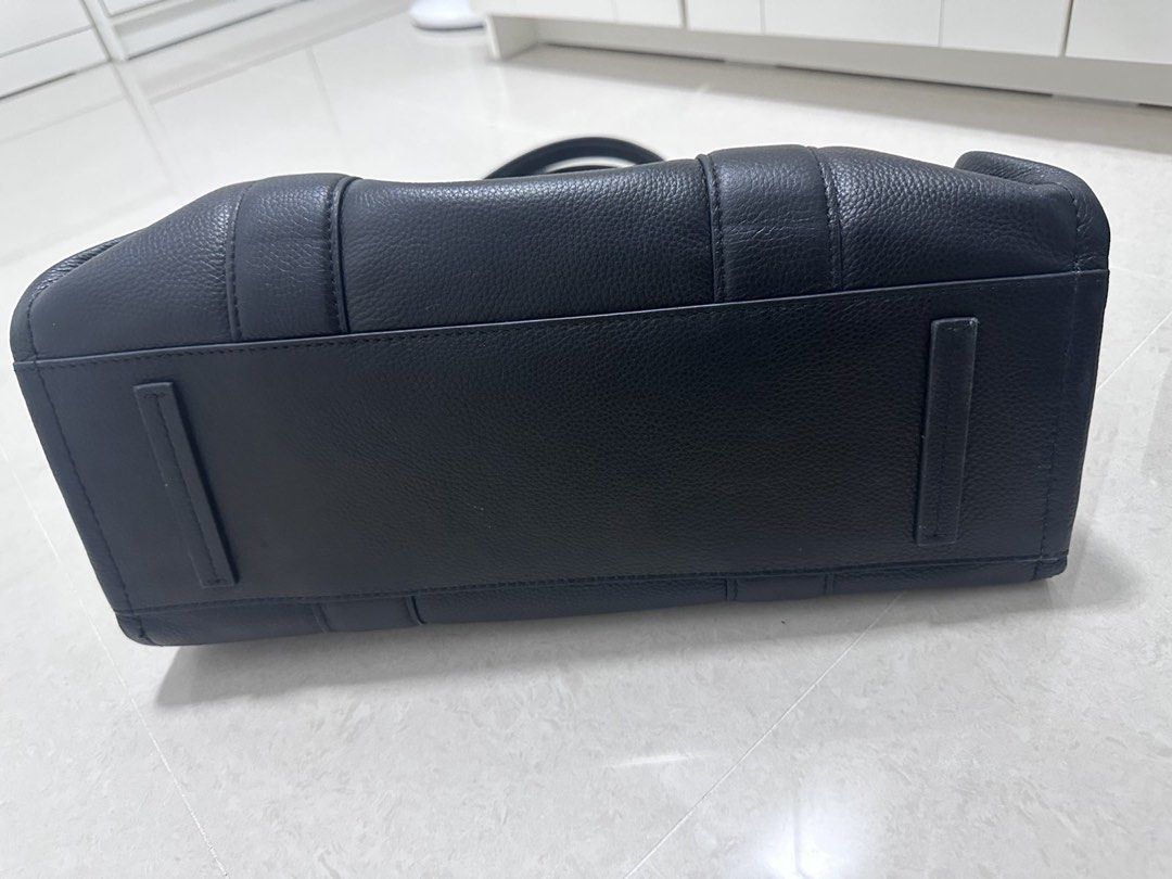 Marc Jacobs The Tote Bag Black Leather (Category: Luxury Bags & Wallets) located in Cavite. Submitted by villary (Listing ID 1457608115, Image 3). Description: - Brand: Marc Jacobs - Material: Black Leather - Design: "The Tote Bag" logo printed on front - Closure: Zipper at the top - Interior: One zippered pocket - Base: Structured with protective feet - Ideal for: Everyday use.