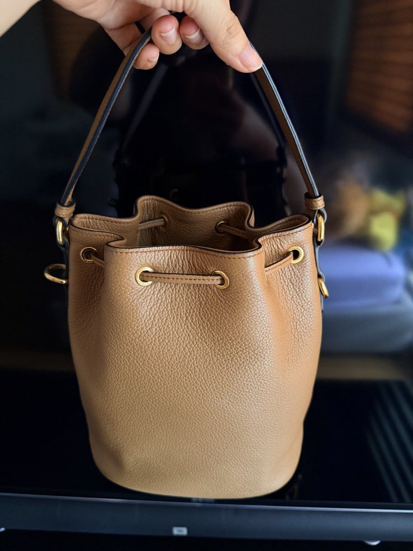 PRADA Vitello Phenix Brown Bucket Bag (Category: Luxury Bags & Wallets) located in San Fernando. Submitted by ms.mlsluxeboutique (Listing ID 1457547171, Image 2). Description: •100% authentic or money back guarantee if proven fake •With dust bag, long strap and legit grails (rfid already) •9.5/10 condition •No visible damage (minimal scuffs only).