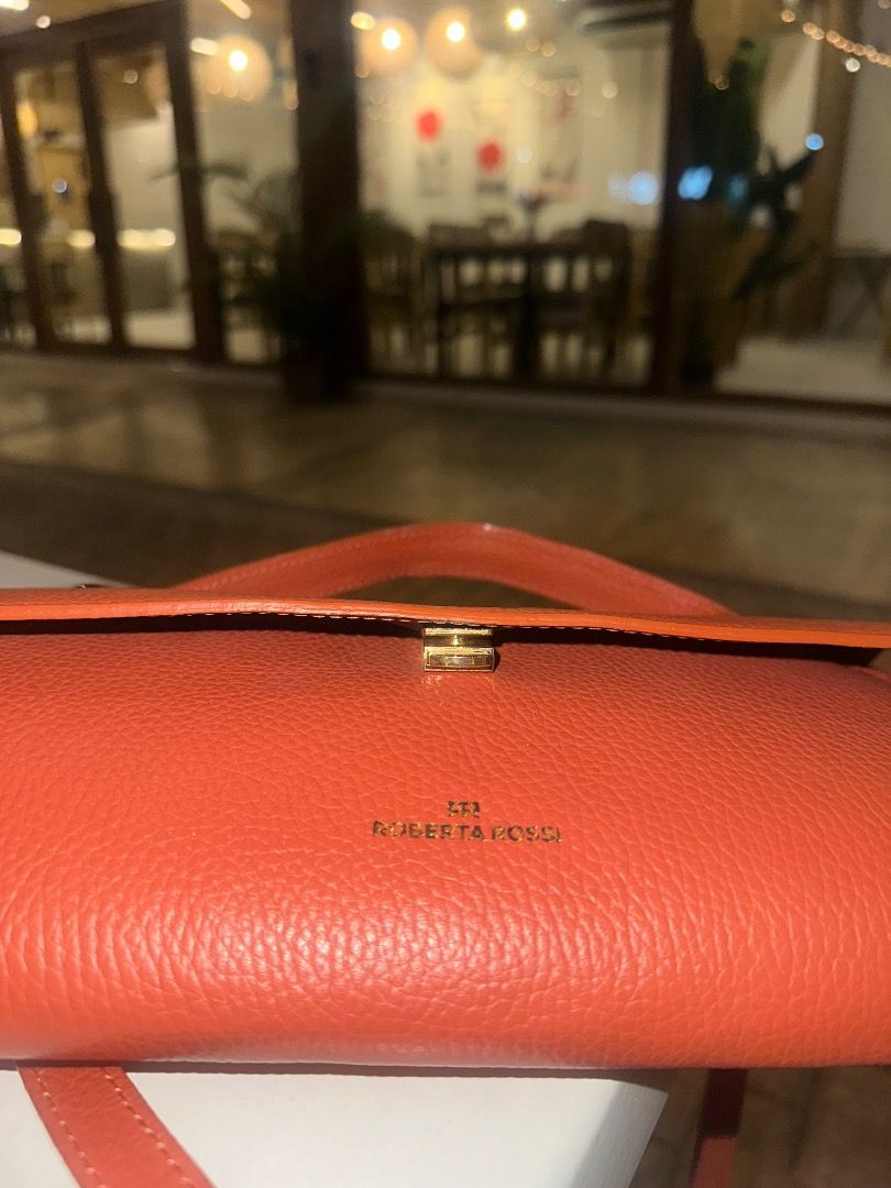 Roberta Rossi Orange Leather Cylindrical Handbag (Category: Luxury Bags & Wallets) located in Caloocan City. Submitted by ayajaneee (Listing ID 1457655862, Image 3). Description: - Brand: Roberta Rossi - Color: Orange - Material: Leather - Shape: Cylindrical - Features: Top handle, detachable shoulder strap, main compartment, internal zip pocket - Hardware: Gold - Versatile: Ideal for everyday use or evening events.