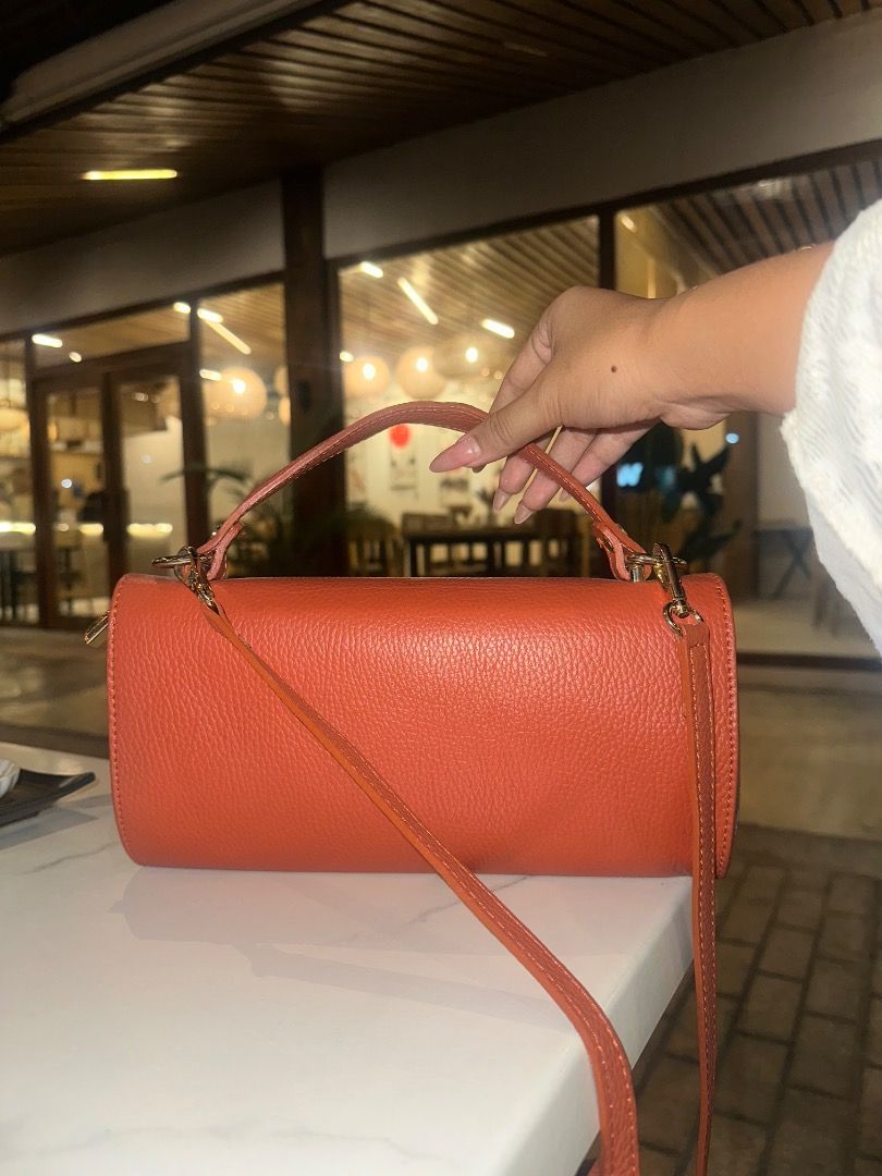 Roberta Rossi Orange Leather Cylindrical Handbag (Category: Luxury Bags & Wallets) located in Caloocan City. Submitted by ayajaneee (Listing ID 1457655862, Image 2). Description: - Brand: Roberta Rossi - Color: Orange - Material: Leather - Shape: Cylindrical - Features: Top handle, detachable shoulder strap, main compartment, internal zip pocket - Hardware: Gold - Versatile: Ideal for everyday use or evening events.