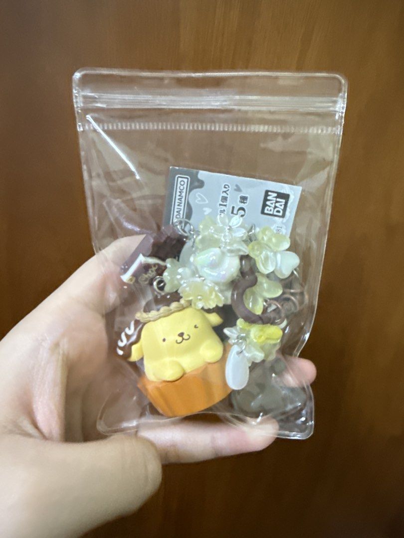 Sanrio Characters Chocolate Doll Pompompurin Keychain Charm (Category: Character Goods) located in San Juan City. Submitted by candycane27 (Listing ID 1457645809, Image 2). Description: - Adorable Pompompurin keychain charm - Part of the Sanrio Characters Chocolate Doll series - Features cute chocolate bar and flower charms - Ideal for decorating bags, backpacks, or keys - Authentic Bandai product.