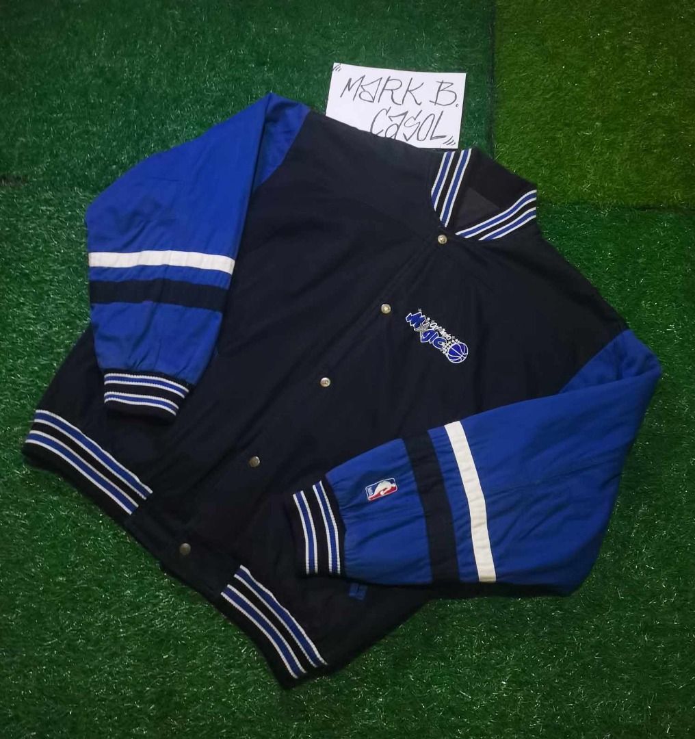 Vintage Reversible Orlando Magic NBA Satin Bomber Jacket (Category: Coats, Jackets and Outerwear) located in Taytay. Submitted by markcasol45 (Listing ID 1457634975, Image 2). Description: - Vintage Orlando Magic jacket - Features embroidered team logo on front and back - Classic blue and black colorway - Striped cuffs and collar for added style - Made by Unishine - Size Large (L) - Perfect for any Orlando Magic fan!.