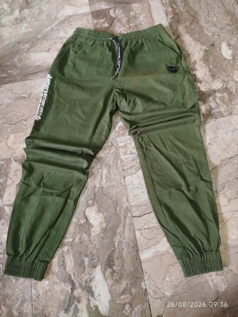 AAPE BY A BATHING APE Cargo Pants Green (Category: Jeans) located in Manila. Submitted by mr.connection (Listing ID 1457726519, Image 2). Description: - Brand: AAPE BY A BATHING APE - Color: Green - Features: Iconic ape head logo on back pocket, text graphic on side - Waist: Elastic waistband with drawstring - Ankles: Cuffed - Style: Great for casual wear.