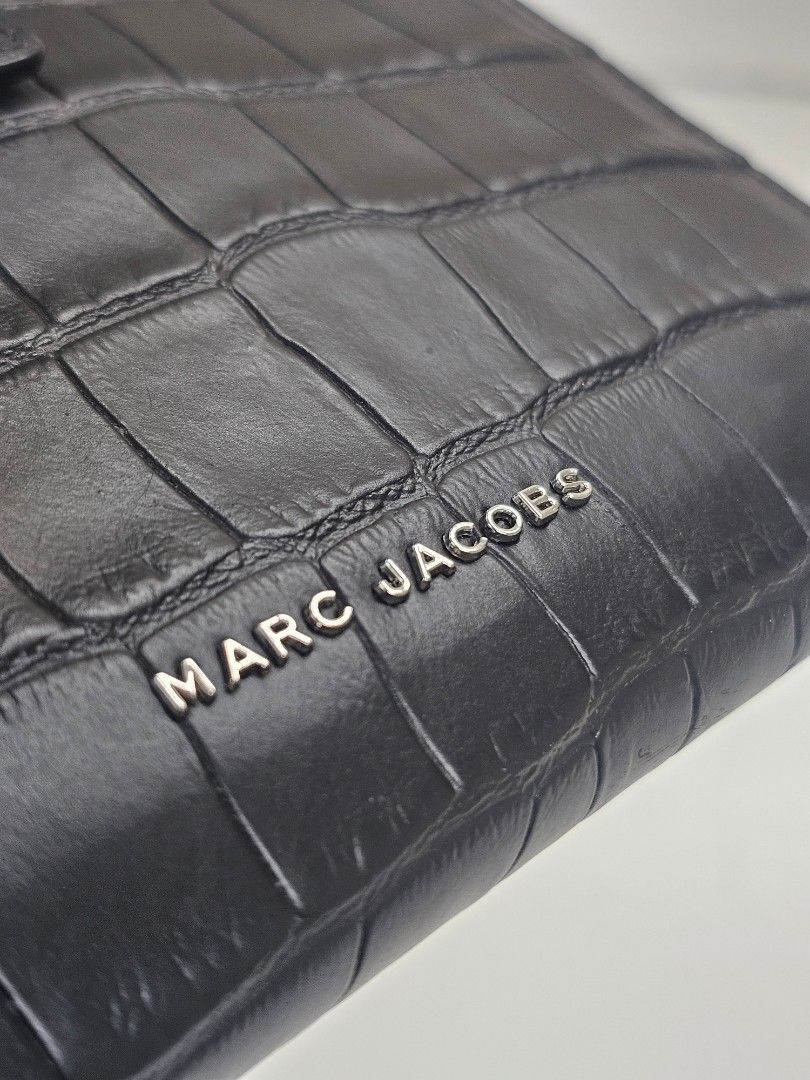 Authentic Marc Jacobs Black Croc Embossed Leather Wallet (Category: Luxury Bags & Wallets) located in Muntinlupa City. Submitted by sanctuaryglam (Listing ID 1457763242, Image 3). Description: Brandnew without Tags Source: U.S.A FREE SHIPPING - Genuine black leather with stylish croc embossing - Secure snap button closure - Convenient zip-around compartment for added security - Detachable wrist strap for easy carrying - Ample space for all your c