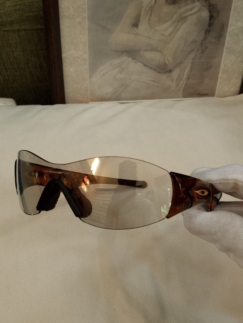 Authentic Oakley Zero S Sunglasses Gray Lenses Amber Brown Frame (Category: Sunglasses & Eyewear) located in Binangonan. Submitted by stufflikedat (Listing ID 1457797292, Image 1). Description: Authentic Oakley Zero S sunglasses in dark amber frame with gray lenses, lightweight minimalist rimless shield design with signature gold Oakley ellipse icons on the temple in excellent pre loved condition, very light & minimal scratches only, made in USA,