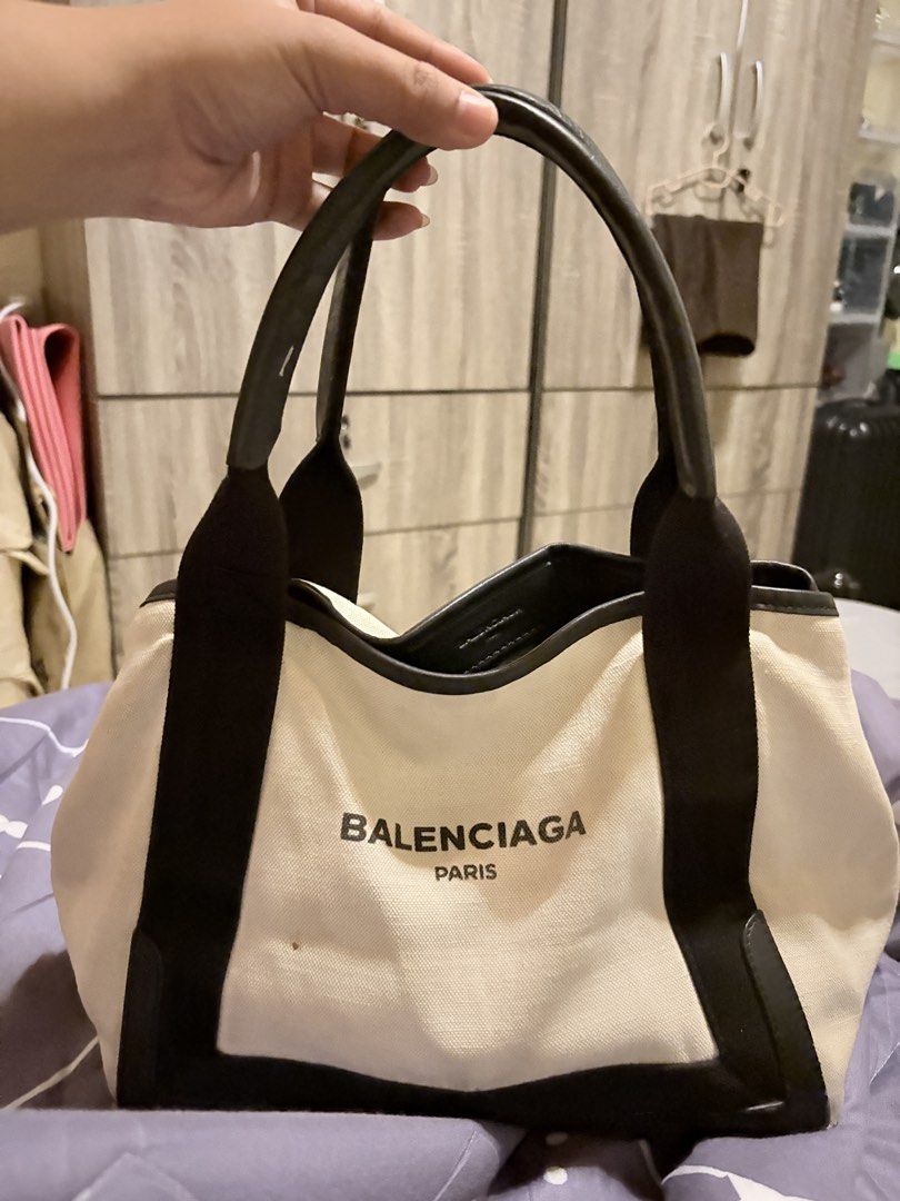 Balenciaga Paris Canvas Tote Bag (Category: Luxury Bags & Wallets) located in Caloocan City. Submitted by fierce_mica29 (Listing ID 1457715365, Image 1). Description: - Balenciaga Paris tote bag - Color: Cream canvas with black leather trim - Closure: Top zipper - Includes: Separate zippered pouch - Condition: Minor marks on canvas (especially pouch), zipper pull shows wear - Perfect for everyday use .
