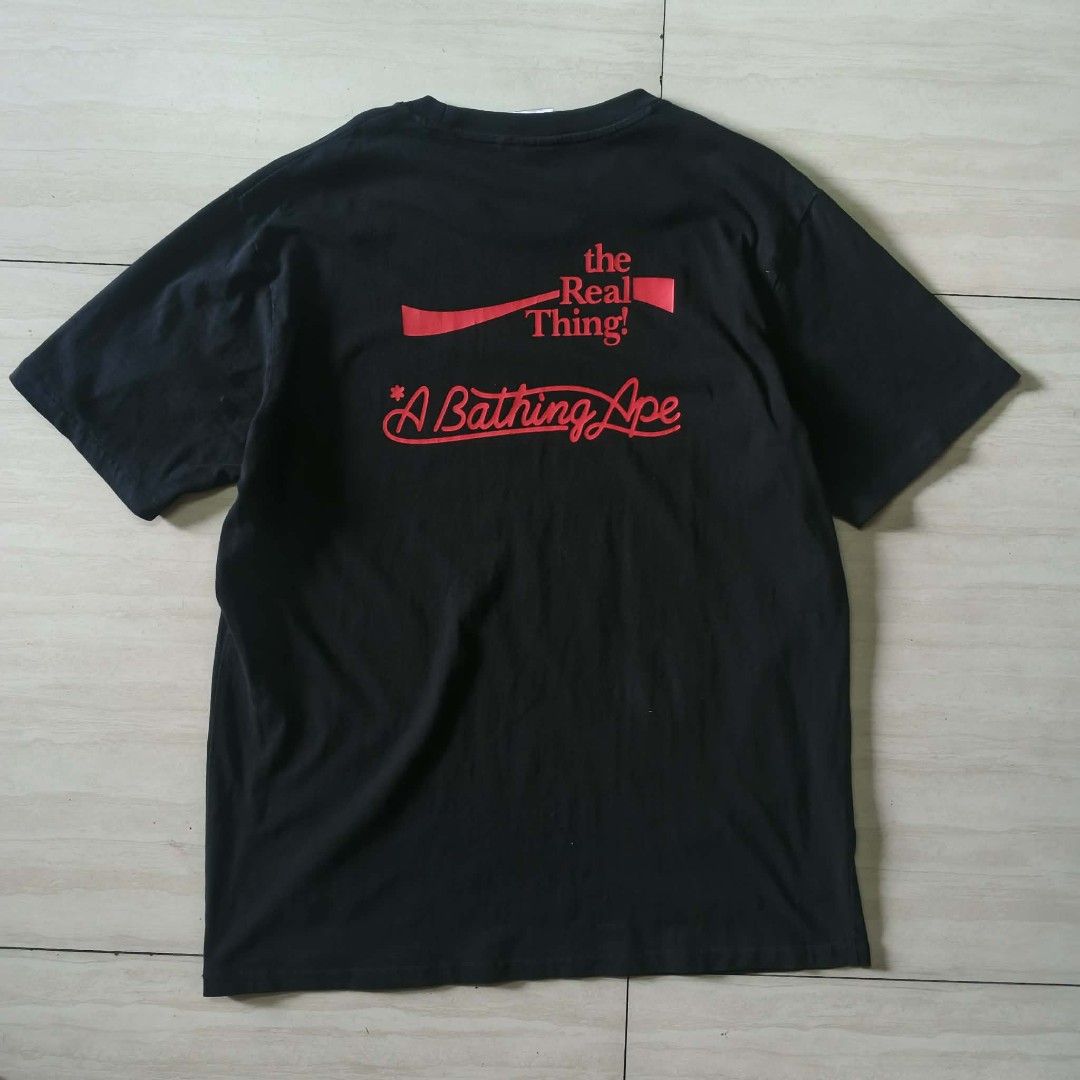 BAPE x Coca-Cola Tee Black (Category: Tshirts & Polo Shirts ) located in Paranaque City. Submitted by thriftine5 (Listing ID 1457783380, Image 2). Description: - Authentic BAPE x Coca-Cola Collaboration T-Shirt - Color: Black - Size: [Insert Size Here] - Front Design: Iconic BAPE ape head graphic filled with stars, Coca-Cola branding - Back Design: 'the Real Thing!' and 'A Bathing Ape' text - Perfect for collectors and streetwear enthusiasts - Ch