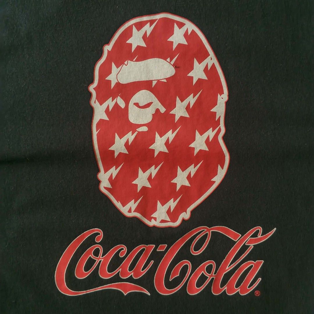 BAPE x Coca-Cola Tee Black (Category: Tshirts & Polo Shirts ) located in Paranaque City. Submitted by thriftine5 (Listing ID 1457783380, Image 3). Description: - Authentic BAPE x Coca-Cola Collaboration T-Shirt - Color: Black - Size: [Insert Size Here] - Front Design: Iconic BAPE ape head graphic filled with stars, Coca-Cola branding - Back Design: 'the Real Thing!' and 'A Bathing Ape' text - Perfect for collectors and streetwear enthusiasts - Ch