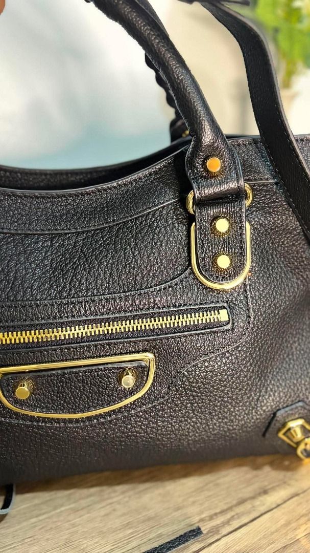Black Leather Handbag with Gold Hardware (Category: Luxury Bags & Wallets) located in Caloocan City. Submitted by lovelj_2026 (Listing ID 1457766621, Image 2). Description: Preloved Japan Bag Black Large Balenciaga - Stylish black leather handbag - Elegant gold hardware details - Convenient front zip pocket - Unique braided handle - Includes a detachable shoulder strap - Ample interior space for essentials - Versatile for everyday wear or evening