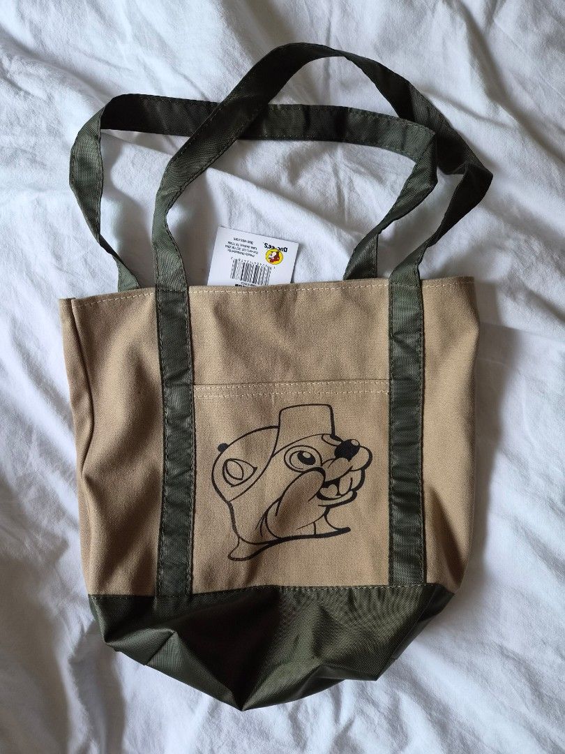 Buc-ee's Tote Bag (Category: Tote Bags) located in Las Pinas. Submitted by storage485 (Listing ID 1457860092, Image 1). Description: - Adorable Buc-ee's canvas tote bag - Features a cute cartoon character design - Stylish tan and olive green color - Sturdy, durable handles for comfortable carrying - Ideal for everyday errands, shopping, or as a fun accessory.