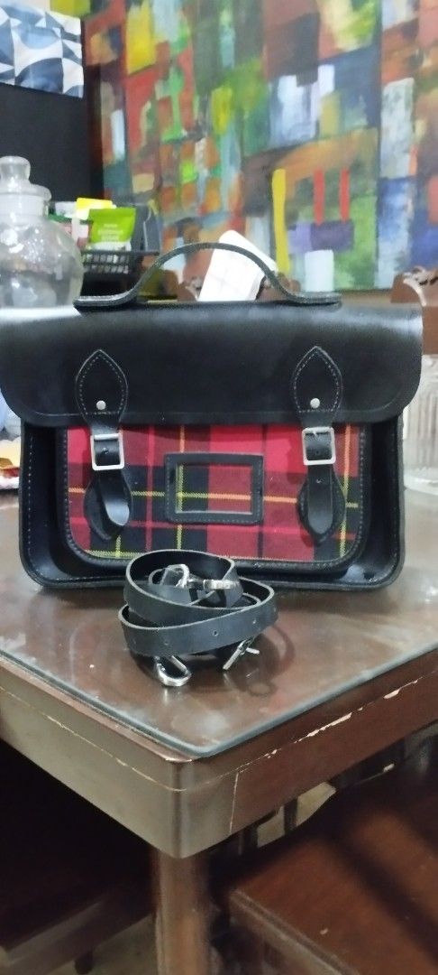 Cambridge Black Leather Satchel Bag (Category: Luxury Bags & Wallets) located in Manila. Submitted by beckster_nnline_luxuryshop (Listing ID 1457843420, Image 3). Description: - Classic black leather satchel - Red tartan fabric panel on the front 12 X 9 X 2.5 - Secure buckle closures - Comfortable top handle - Detachable shoulder strap for versatility - Roomy interior for all your essentials - Ideal for school or everyday carry SIZE: 12 X 9 X 2.5