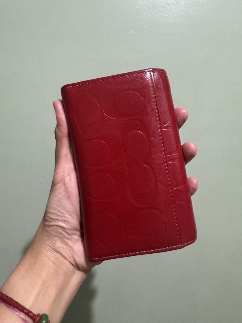 Coach Red Monogram Leather Bifold Wallet (Category: Luxury Bags & Wallets) located in Pasay City. Submitted by mydeer08 (Listing ID 1457879101, Image 1). Description: - Authentic Red Coach wallet - Signature monogram pattern - Made in Spain - Genuine leather interior - Features card slots - Includes a zip compartment - Interior shows some signs of wear - Plenty of life remaining.