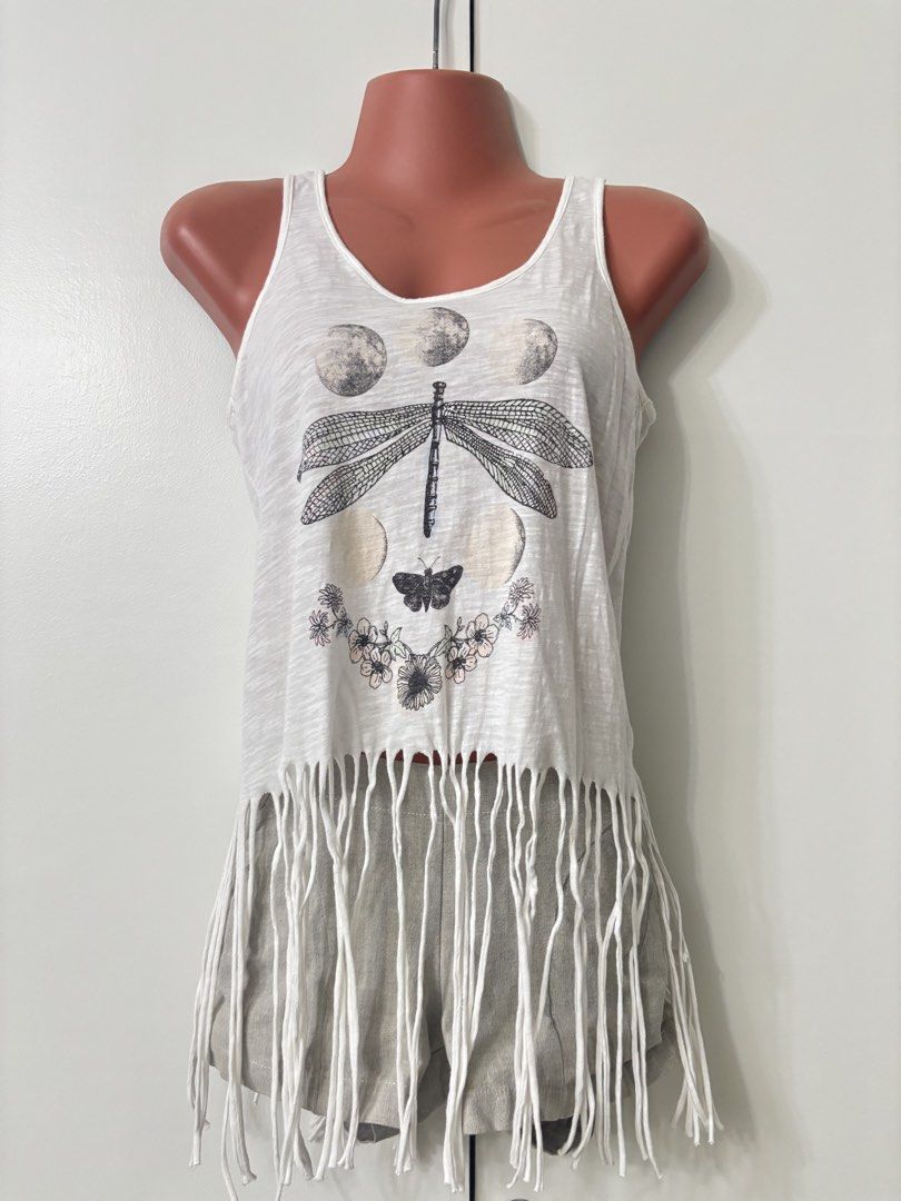 Coachella Fringe Tank Top (Category: Sleeveless) located in Taguig. Submitted by wena11 (Listing ID 1457802570, Image 2). Description: Bethany Mota White Dragonfly Moon Fringe Tank Top XS - Brand: Bethany Mota by Aeropostale - Color: cream/off White - Size: XS - Design: Dragonfly and moon graphic - Detail: Fringe at the bottom hem - Material: 100% Cotton Used once only You can tie or untie the fringes depending on the look you want to go for. ***