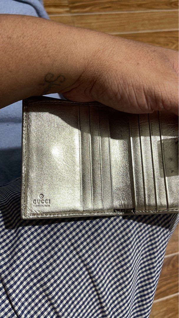 Gucci GG Monogram Wallet Silver Metallic Leather (Category: Luxury Bags & Wallets) located in Mandaluyong City. Submitted by mark2pac (Listing ID 1457836879, Image 3). Description: - Authentic Gucci bi-fold wallet - Silver metallic leather with signature GG monogram - Snap closure - Multiple interior card slots and compartments - Made in Italy - Shows some signs of wear on the interior lining - Functional and stylish piece.