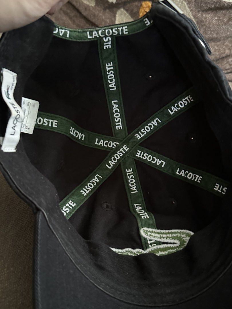 Lacoste Cap (Category: Caps & Hats) located in Subic. Submitted by declutterbyshit (Listing ID 1457888509, Image 2). Description: - Classic black Lacoste cap - Features iconic green crocodile logo embroidered on the front - Brand name repeated on internal bands - Adjustable strap at the back for a comfortable fit - Versatile accessory for casual outfits.