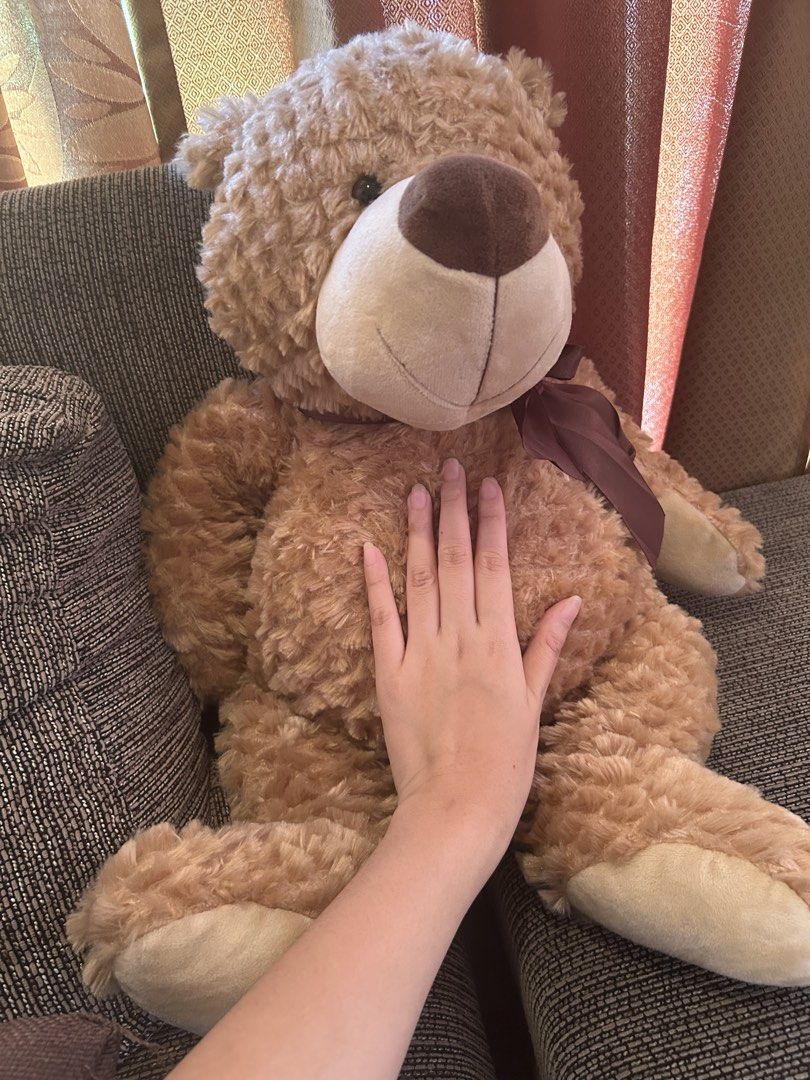 Large Brown Teddy Bear Plush Toy (Category: Plushies & Soft Toys) located in Quezon City. Submitted by bmswardrobe (Listing ID 1457761214, Image 3). Description: - Big and fluffy teddy bear - Super soft and cuddly - Features a cute ribbon around its neck - Minor tear on the back, requires a simple stitch - Ideal for hugs or as a room decoration.
