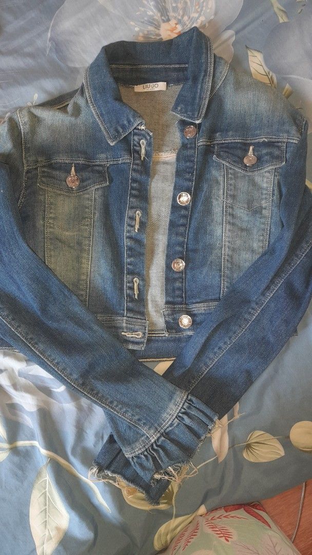 Liu Jo Denim Jacket (Category: Coats, Jackets and Outerwear) located in Bay. Submitted by silverhorse-59c851 (Listing ID 1457753417, Image 1). Description: - Classic blue denim jacket by Liu Jo - Button-up front closure - Two chest pockets - Distressed, frayed cuffs for a stylish look - Ideal for layering and versatile styling.