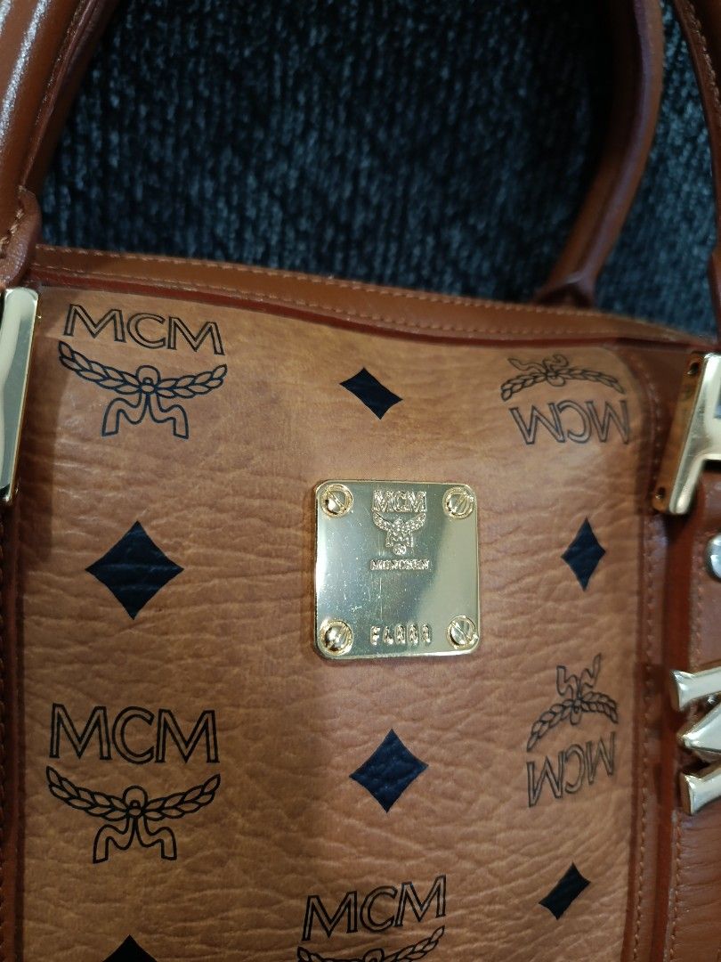MCM Monogram Boston Bag with Charm (Category: Luxury Bags & Wallets) located in Cabagan. Submitted by blessingma81004 (Listing ID 1457729890, Image 3). Description: - Classic MCM monogram Boston bag - Color: Brown and black - Signature MCM charm included - Gold hardware details - Top handles for comfortable carrying - Secure zipper closure - Ideal for everyday use.