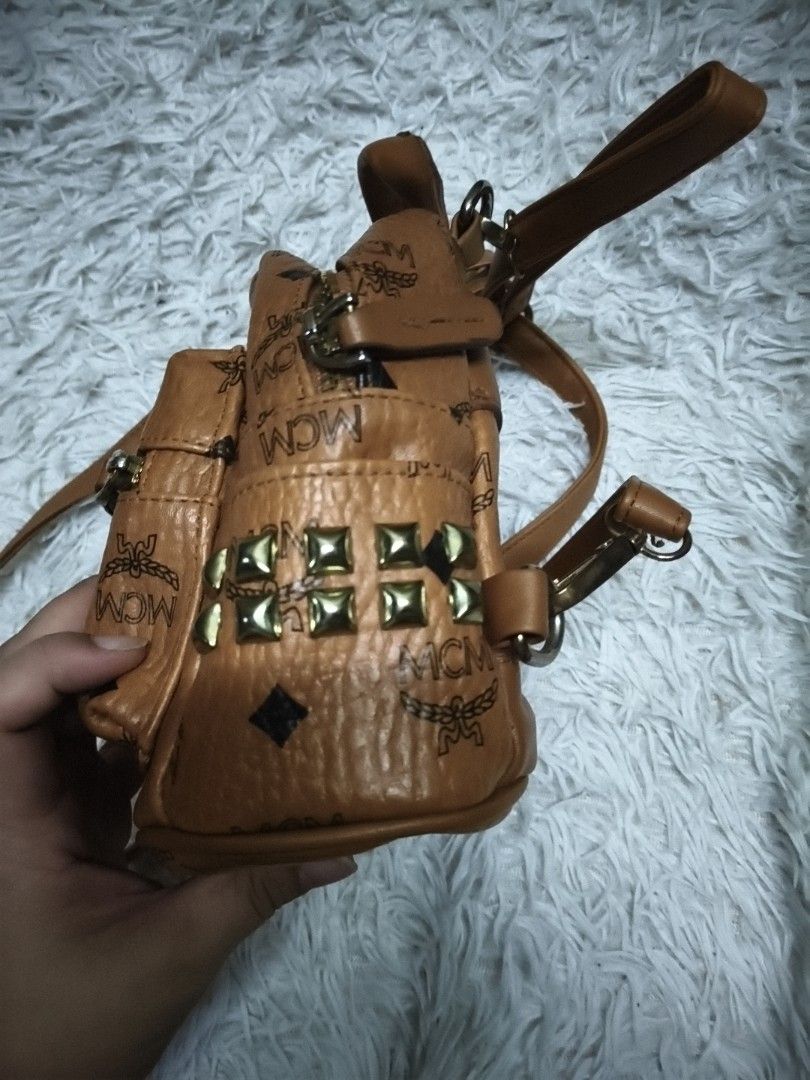 MCM Monogram Mini Backpack Brown Studded (Category: Backpacks) located in Pasay City. Submitted by cory0223 (Listing ID 1457883303, Image 2). Description: - Authentic MCM mini backpack - All-over signature monogram print - Stylish gold-tone studs on the sides - Adjustable shoulder straps for comfort - Convenient top handle - Secure zipper closure - Compact size, ideal for essentials.