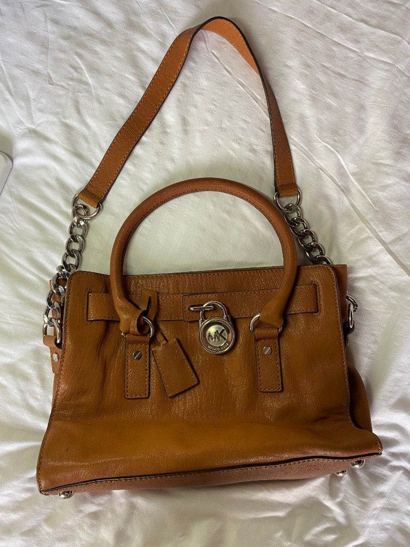 Mk hamilton (Category: Luxury Bags & Wallets) located in Paranaque City. Submitted by itsmemichel (Listing ID 1457864510, Image 1). Description: brown leather two rounded top handles chain-link shoulder strap gold-tone logo padlock Condition: GOOD. This previously owned and used item is in good condition with minimal signs of use. This may include little fading of material and scratches which is normal in 2nd hand bags. but over all in good condi