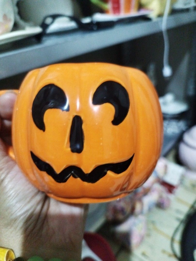 Orange Pumpkin Face Mug (Category: Coffee & Tea Tableware) located in Manila. Submitted by silverwhale_cafa21 (Listing ID 1457866614, Image 2). Description: - Adorable orange mug shaped like a pumpkin. - Features a carved jack-o'-lantern face. - Ideal for Halloween or fall-themed beverages. - Easy-to-grip handle. 📌📌with Paint Chip sa mouth.
