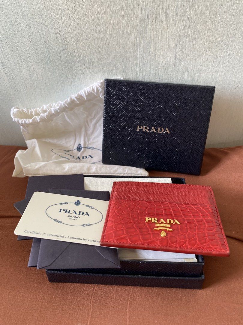 Prada Red Crocodile Embossed Leather Card Holder (Category: Luxury Bags & Wallets) located in Taguig. Submitted by sandzclick (Listing ID 1457755642, Image 2). Description: - Authentic Prada card holder - Stunning red color with crocodile embossed leather - Elegant gold Prada logo on the front - Multiple card slots for organization - Comes with original box, dust bag, and authenticity card - Perfect for stylishly organizing your cards.