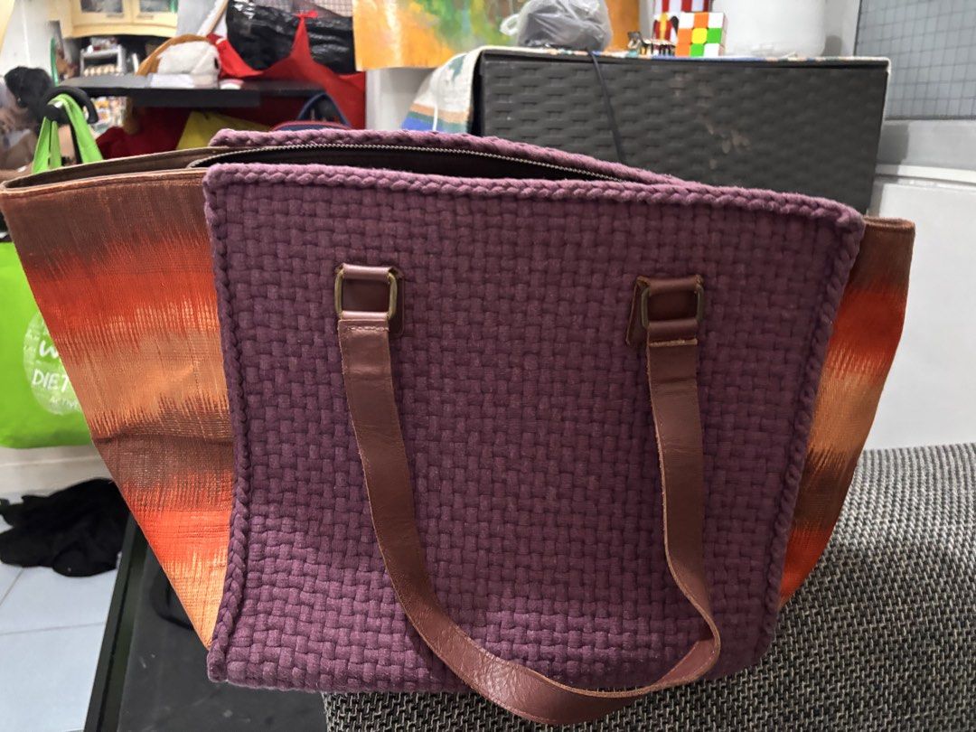 Purple Woven Tote Bag with Orange Accent (Category: Tote Bags) located in Manila. Submitted by bright_lamb (Listing ID 1457733436, Image 1). Description: - Stylish tote bag with a unique woven purple front. - Features a cool abstract pattern in orange and brown on the sides. - Durable and comfortable leather handles. - Secure zipper closure at the top. - Plenty of interior space, perfect for everyday essentials or weekend getaways..