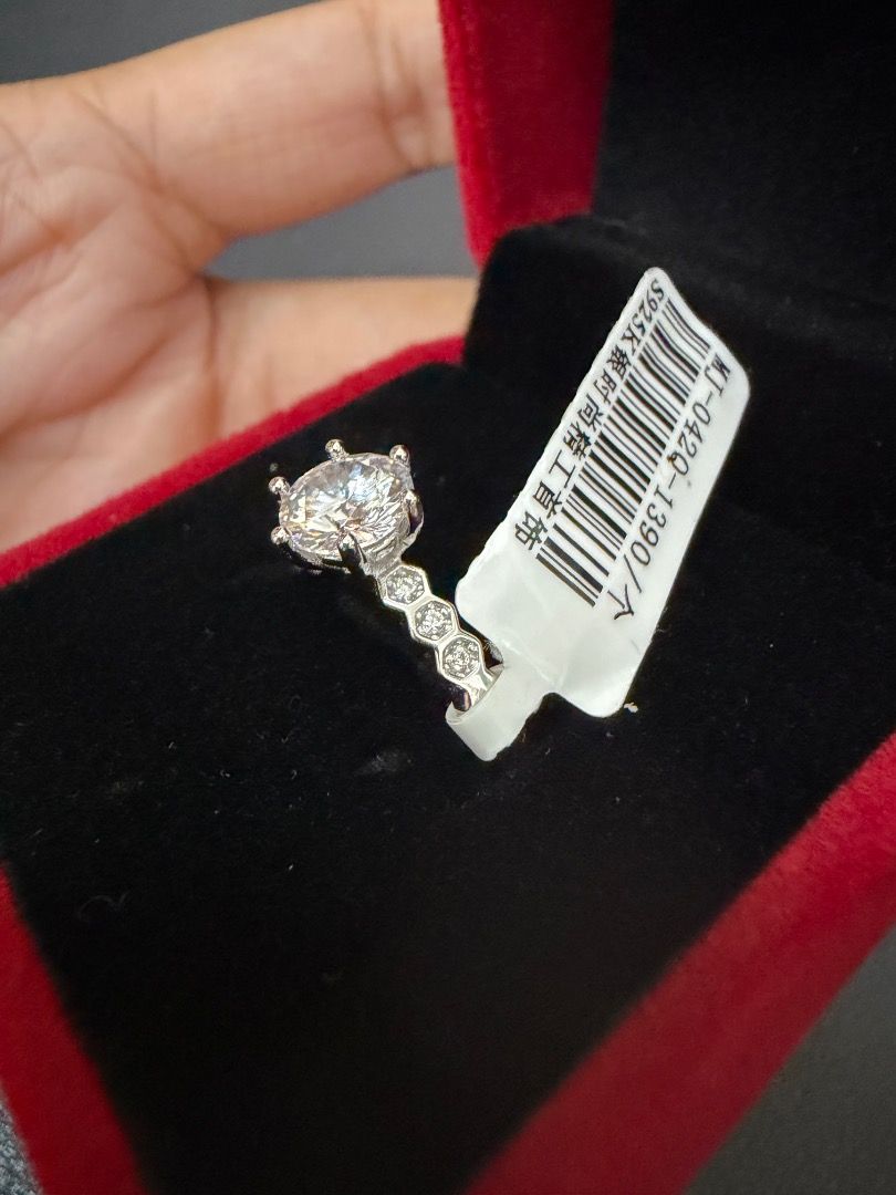 S925 Sterling Silver Ring with Moissanite stone (Category: Rings) located in Caloocan City. Submitted by annah001 (Listing ID 1457872037, Image 2). Description: - Beautiful ring with a 1.0ct moissanite center stone - Smaller stones accent the band - Unique honeycomb-textured band - Stamped S925 (Sterling Silver) - Adjustable band for perfect fit - Includes a red velvet box.
