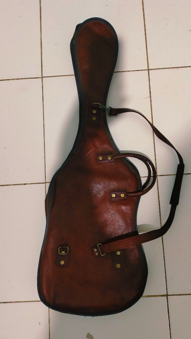 Vintage Leather Guitar Gig Bag Case (Category: Musical Instruments) located in Bulacan. Submitted by babz30261 (Listing ID 1457764367, Image 2). Description: - Brown leather guitar gig bag - Two carry handles - Detachable shoulder strap - Front zip closure - Spacious interior - Shows some wear consistent with age and use - Provides great protection for your guitar.