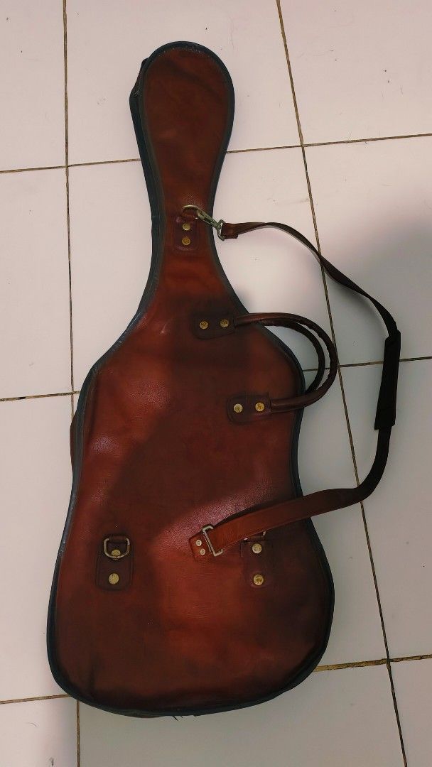 Vintage Leather Guitar Gig Bag Case (Category: Musical Instruments) located in Bulacan. Submitted by babz30261 (Listing ID 1457764367, Image 3). Description: - Brown leather guitar gig bag - Two carry handles - Detachable shoulder strap - Front zip closure - Spacious interior - Shows some wear consistent with age and use - Provides great protection for your guitar.