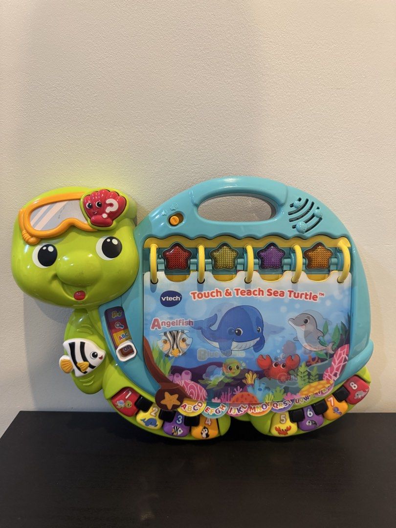 VTech Touch & Teach Sea Turtle (Category: Educational & Learning Toys) located in Paranaque City. Submitted by cellybelly (Listing ID 1457787226, Image 1). Description: - Interactive VTech Touch & Teach Sea Turtle - Teaches ABCs, numbers, and animal names - Features music and sounds for engaging play - Pages flip to reveal different learning activities - Perfect for toddlers learning letters and numbers.