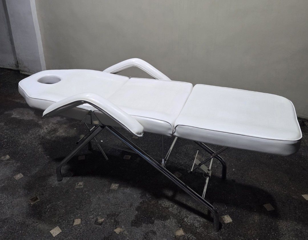 White Adjustable Massage Bed with Face Cradle (Category: Massage Devices) located in Quezon City. Submitted by unimo0212 (Listing ID 1457866907, Image 1). Description: - White massage/facial bed - Ideal for spa, salon, or home use -Perfect for massage, facial, tattoo, piercing, beauty, spa salon and skin clinic -Adjustable back and leg rest to diff angles -Includes removable face cradle pillow -Sturdy metal frame for durability -3 fold padded wit
