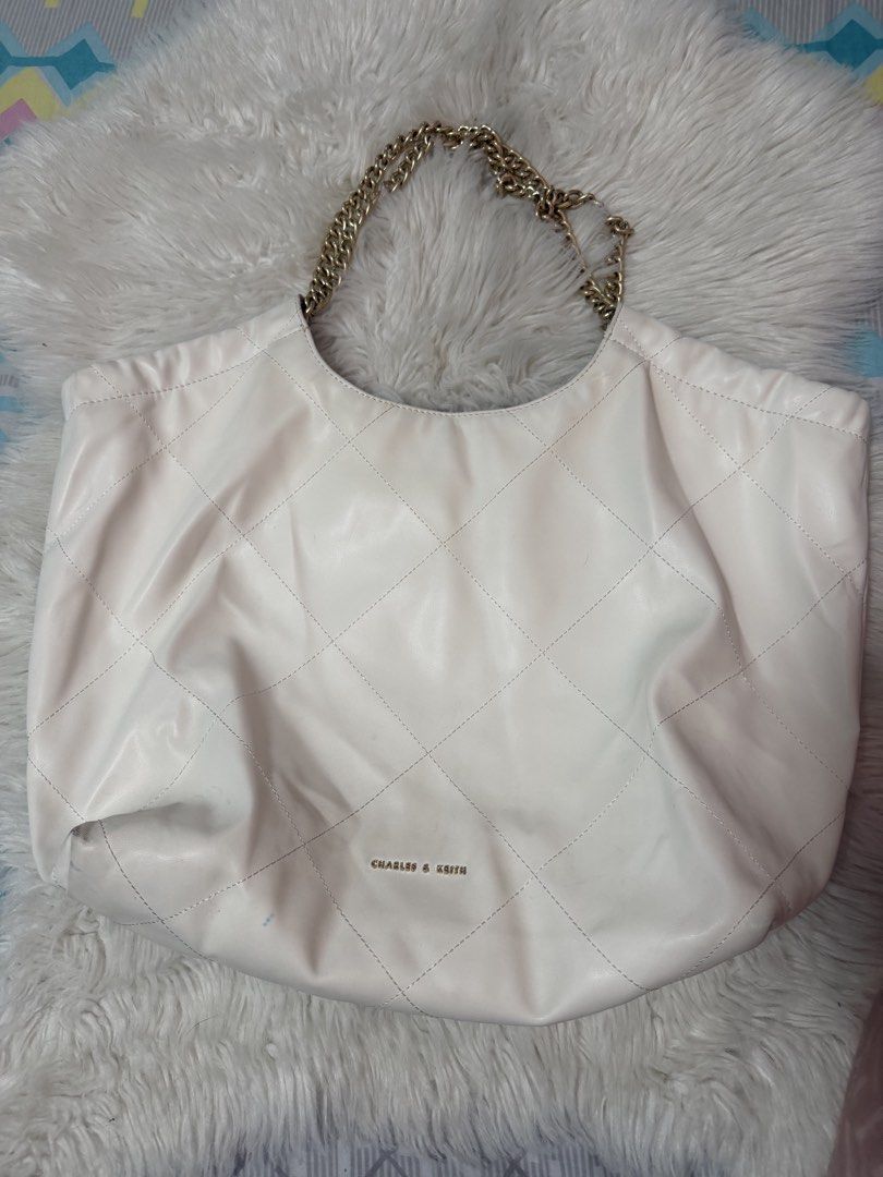 Authentic Charles & Keith Quilted Large (Category: Tote Bags) located in Taguig. Submitted by monethambas (Listing ID 1457930156, Image 1). Description: Condition: Pre-loved condition. Shows visible signs of previous use including light smudges/discoloration on the outer exterior material and minor interior lining staining near the base/seams (please refer to photos for details). Hardware, chain handles, and zipper function smoothly..