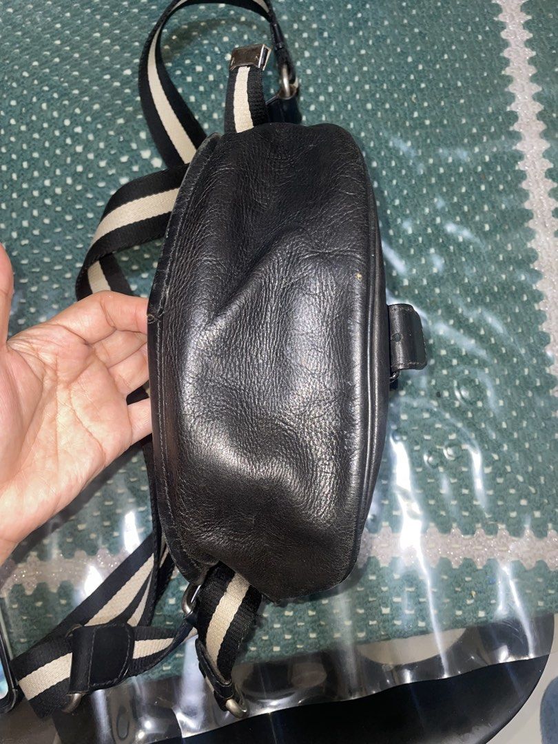 Bally Black Leather Crossbody Bag with Striped Strap (Category: Cross-body Bags) located in Cavite. Submitted by msandysgoodies (Listing ID 1458020145, Image 3). Description: - Authentic Bally black leather crossbody bag - Features the iconic Bally striped strap - Secure buckle closure on the front flap - Interior includes a zippered pocket and a main compartment - Perfect size for carrying daily essentials - Shows some signs of wear on the leath