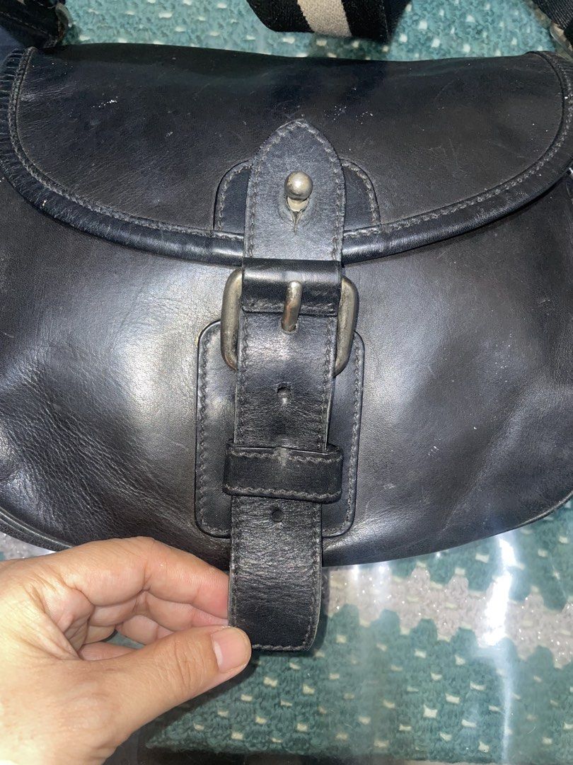 Bally Black Leather Crossbody Bag with Striped Strap (Category: Cross-body Bags) located in Cavite. Submitted by msandysgoodies (Listing ID 1458020145, Image 2). Description: - Authentic Bally black leather crossbody bag - Features the iconic Bally striped strap - Secure buckle closure on the front flap - Interior includes a zippered pocket and a main compartment - Perfect size for carrying daily essentials - Shows some signs of wear on the leath