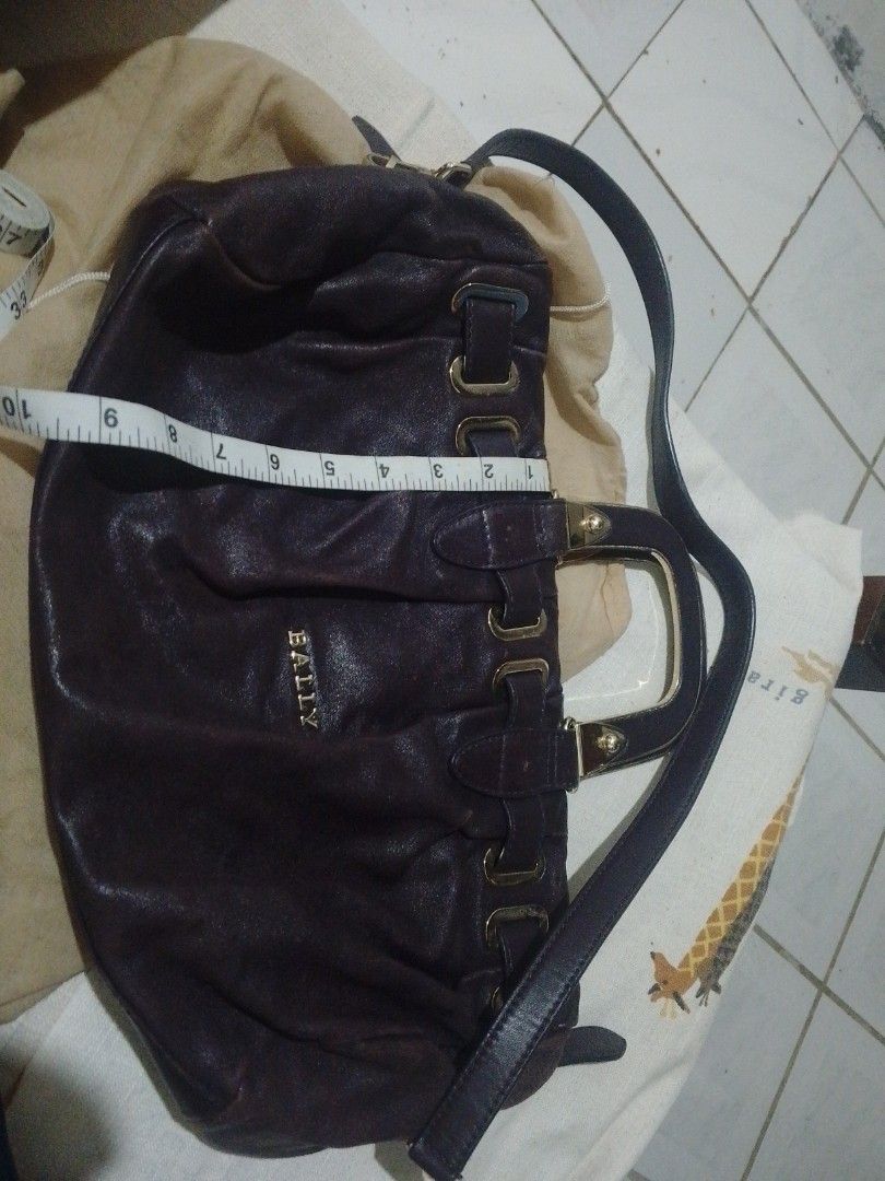 Bally Leather Handbag (Category: Luxury Bags & Wallets) located in Manila. Submitted by raqs17 (Listing ID 1457920519, Image 3). Description: - Authentic dark purple Bally leather handbag - Elegant gold hardware details - Spacious interior with a zippered pocket and main compartment - Generous size: approximately 15 inches wide - Comes with original Bally dust bag - Ideal for everyday wear and versatile styling.