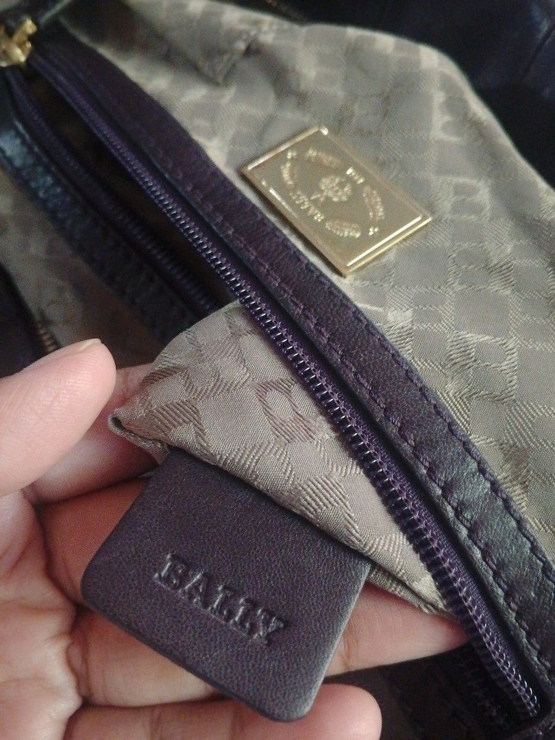 Bally Leather Handbag (Category: Luxury Bags & Wallets) located in Manila. Submitted by raqs17 (Listing ID 1457920519, Image 1). Description: - Authentic dark purple Bally leather handbag - Elegant gold hardware details - Spacious interior with a zippered pocket and main compartment - Generous size: approximately 15 inches wide - Comes with original Bally dust bag - Ideal for everyday wear and versatile styling.