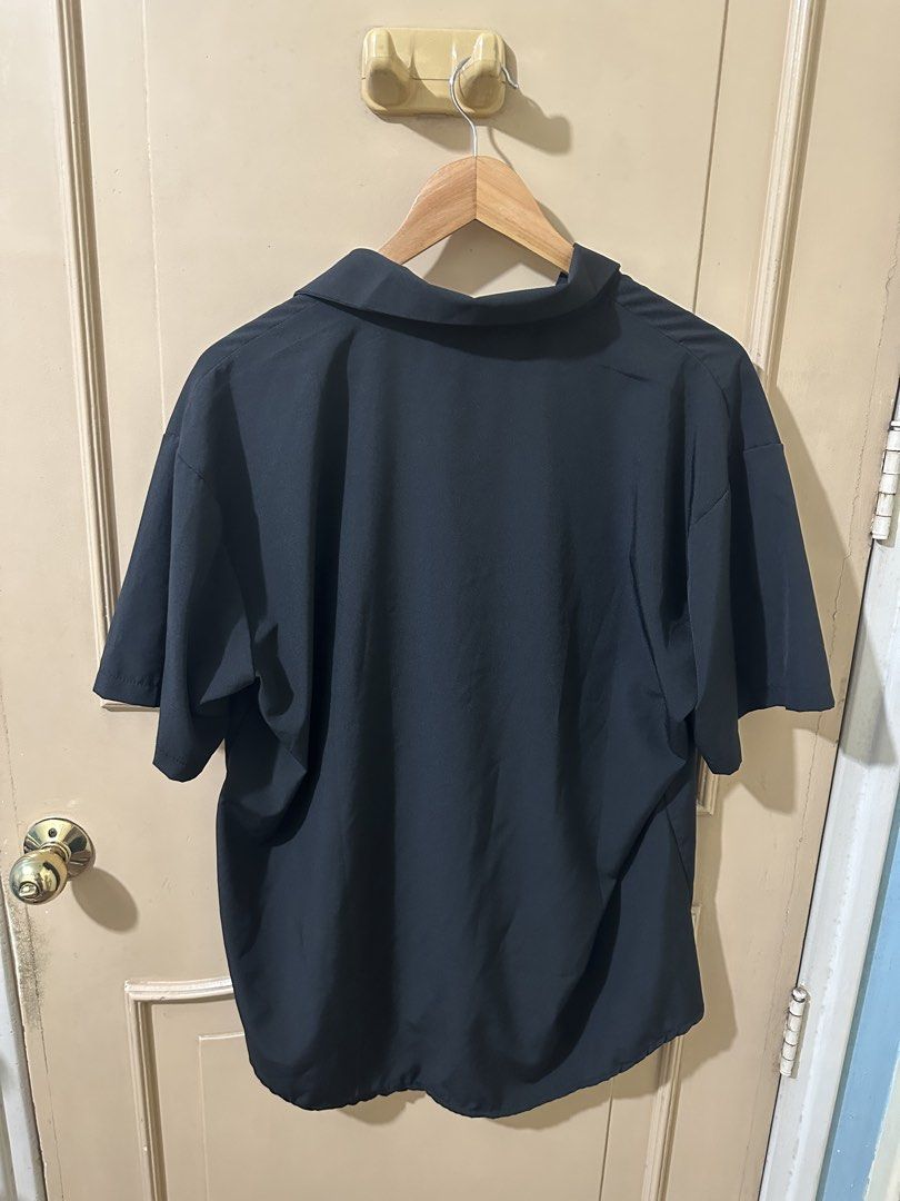 Black Short Sleeve Collared Shirt (Category: Shirts) located in Manila. Submitted by thriftchup (Listing ID 1457982974, Image 2). Description: - Black short sleeve shirt - Collared neckline with V-neck opening - Loose and comfortable fit - Ideal for casual wear or layering - Easy to style.