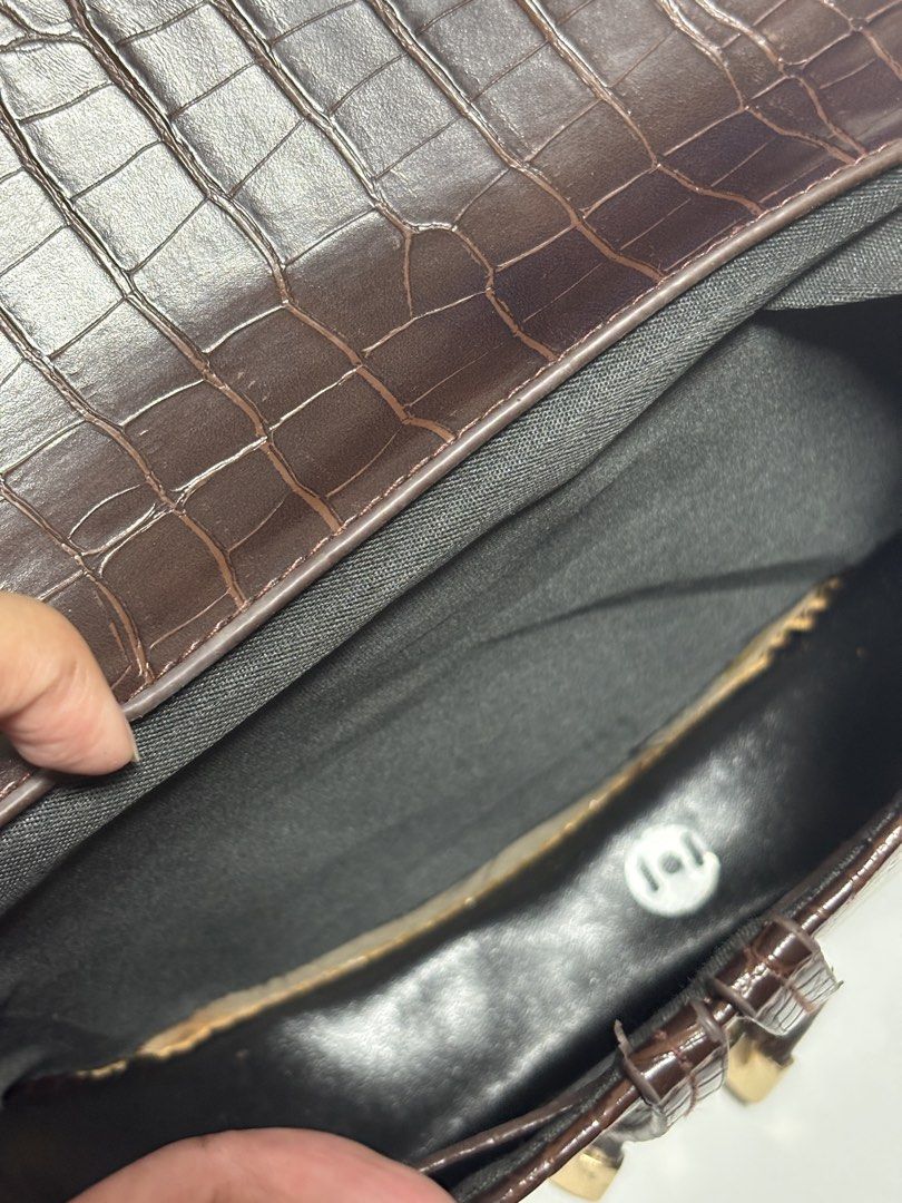 Brown Croc Embossed Saddle Bag with Adjustable Strap (Category: Luxury Bags & Wallets) located in Bacoor. Submitted by sofaritsalright (Listing ID 1457972163, Image 3). Description: - Bought from random store in Bangkok - Have to reglue the lining inside - Stylish brown saddle bag - Luxurious croc-embossed texture - Secure flap closure with elegant gold hardware - Includes a long, adjustable strap for versatile wear - Dark grey interior - Ideal f