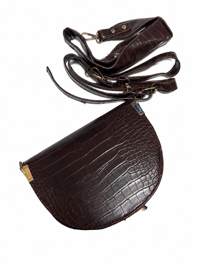 Brown Croc Embossed Saddle Bag with Adjustable Strap (Category: Luxury Bags & Wallets) located in Bacoor. Submitted by sofaritsalright (Listing ID 1457972163, Image 2). Description: - Bought from random store in Bangkok - Have to reglue the lining inside - Stylish brown saddle bag - Luxurious croc-embossed texture - Secure flap closure with elegant gold hardware - Includes a long, adjustable strap for versatile wear - Dark grey interior - Ideal f