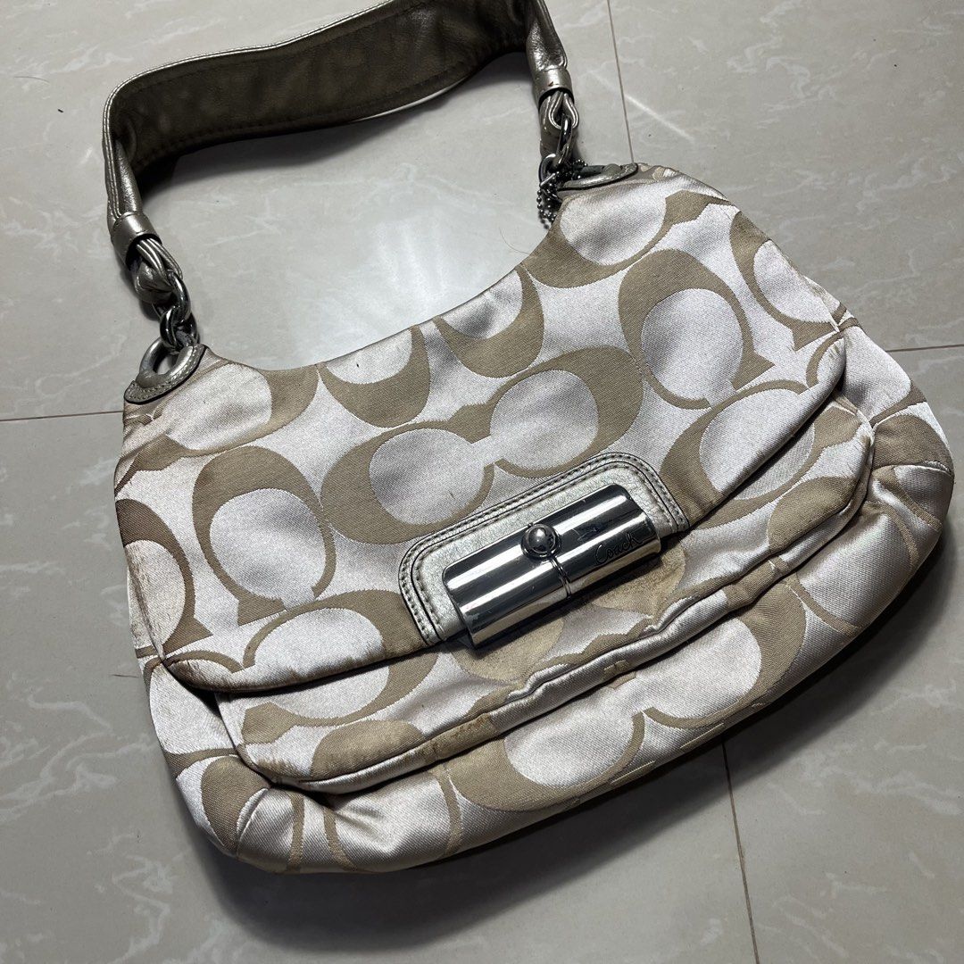 Coach Signature Monogram Shoulder Bag (Category: Luxury Bags & Wallets) located in Manila. Submitted by direcmampu37948 (Listing ID 1458051127, Image 2). Description: - Classic Coach shoulder bag - Signature C monogram pattern (beige/white) - Silver hardware with turn-lock closure - Leather and chain strap - Pink satin interior lining - Minor signs of wear on hardware and edges - Still a stylish and functional piece.