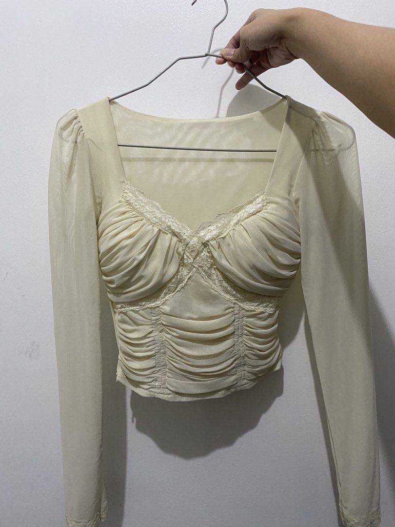 Cream Ruched Corset Top with Sheer Sleeves (Category: Blouses) located in Taguig. Submitted by kmgrce (Listing ID 1458039416, Image 2). Description: Sexy + soft girl vibe 🎀 Super soft and body-hugging, with built-in chest padding. It also has a working side zipper. RFS: Wrong size.