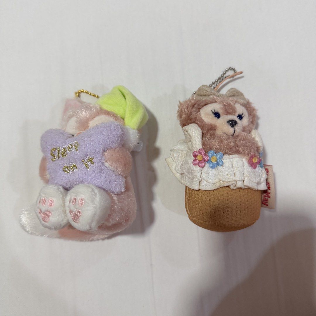 Disney Duffy & Friends Sleepy & Cupcake Plush Keychains (Category: Plushies & Soft Toys) located in Caloocan City. Submitted by preloveditemsbyyana (Listing ID 1458074059, Image 1). Description: - Adorable plush keychains, perfect for decorating bags or as gifts. - Pink Duffy bear keychain: Features a green sleep mask and a purple pillow with 'Sleep on it' text. - Brown bear keychain: Dressed as a cute cupcake with white lace trim and small flowe