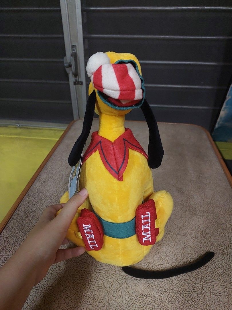 Disney Store Pluto Christmas Plush Toy (Category: Plushies & Soft Toys) located in Manila. Submitted by newdeer.eaa070 (Listing ID 1457967284, Image 2). Description: - Cute Disney Store Pluto plush toy - Dressed in a festive Christmas outfit - Features 'MAIL' details on paws - Includes 'To: Santa North Pole' tag - Soft and cuddly - Perfect for Disney fans and holiday decor.