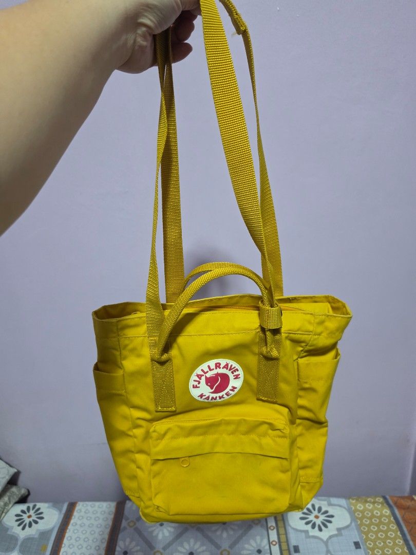 Fjallraven Kanken Mini Totepack Yellow (Category: Backpacks) located in Manila. Submitted by mayanndayang (Listing ID 1458016979, Image 3). Description: - Authentic Yellow Fjallraven Kanken Mini totepack - Iconic logo patch on the front - Two convenient side pockets - Spacious main compartment with zipper closure - Adjustable shoulder straps for comfortable carrying - Dual top handles for alternative carrying options - Interior name tag and a sma