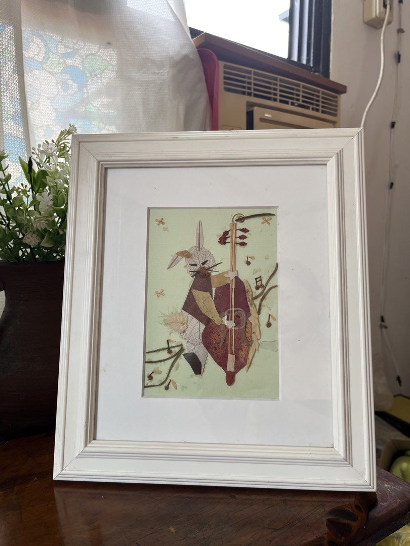 Framed Artwork: Rabbit Playing Cello (Category: Art & Prints) located in Taguig. Submitted by minmin_parker (Listing ID 1457953880, Image 1). Description: - Adorable framed artwork featuring a rabbit playing the cello. - Unique art made from pressed leaves and natural materials. - Comes in a simple white frame. - Ideal for a nursery or adding a touch of whimsy to any room. - Measures approximately [insert dimensions if known]..