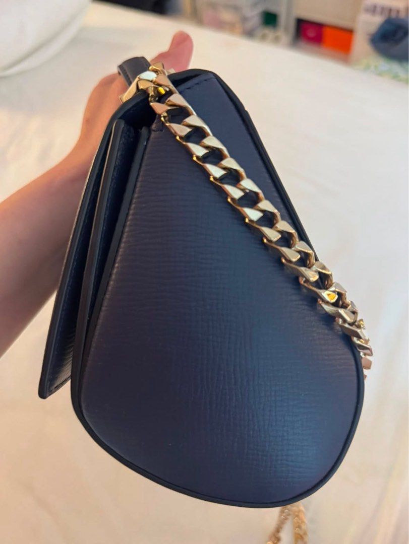Givenchy Navy Leather Chain Shoulder Bag (Category: Luxury Bags & Wallets) located in Quezon City. Submitted by tinemarcelo (Listing ID 1457922638, Image 3). Description: - Authentic Givenchy navy blue leather handbag - Features a luxurious gold chain strap - Includes a convenient top handle - Beautiful textured leather finish - Compact size, ideal for carrying essentials - Shiny gold hardware adds a touch of elegance - Interior is clean and well